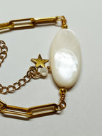 Vue rapprochée de la perle de nacre ovale et du pendentif étoile dorée du Bracelet AVA, mettant en évidence les finitions.