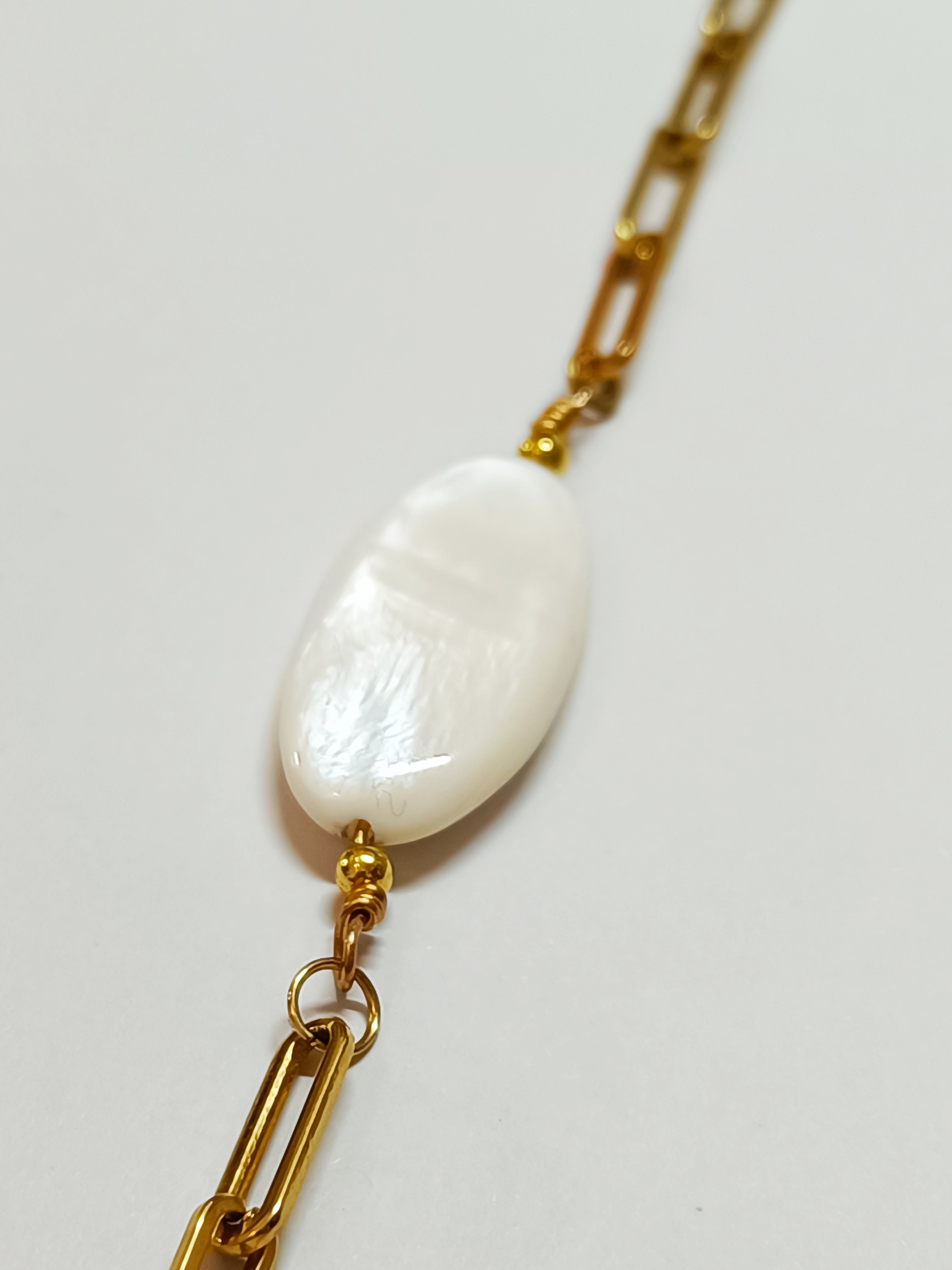 Détail de la perle de nacre naturelle ovale irisée du Bracelet AVA, montrant sa texture et ses reflets uniques.