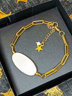 Bracelet AVA en nacre naturelle et chaîne dorée, avec pendentif étoile, présenté dans un élégant écrin noir