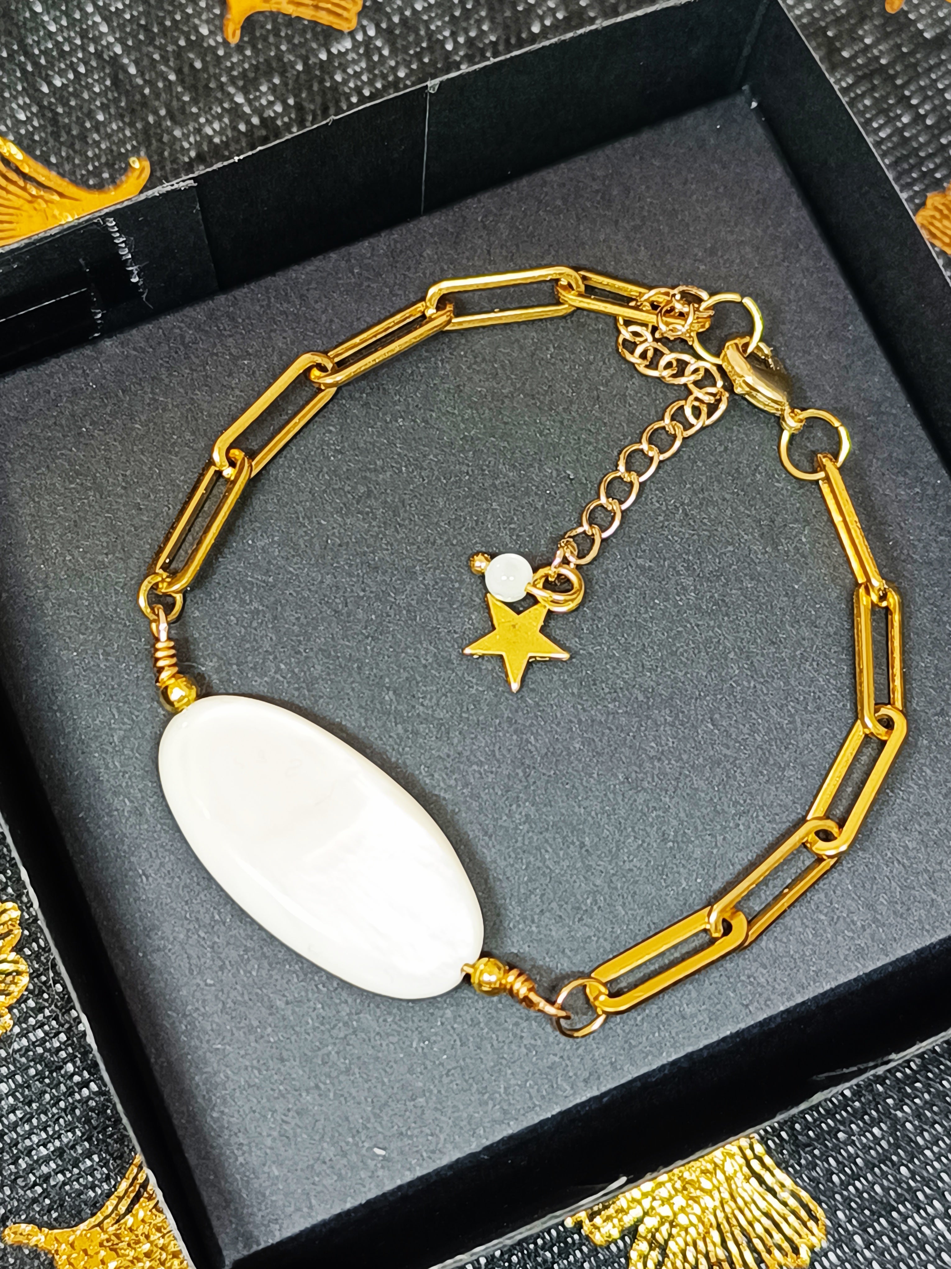 Bracelet AVA en nacre naturelle et chaîne dorée, avec pendentif étoile, présenté dans un élégant écrin noir