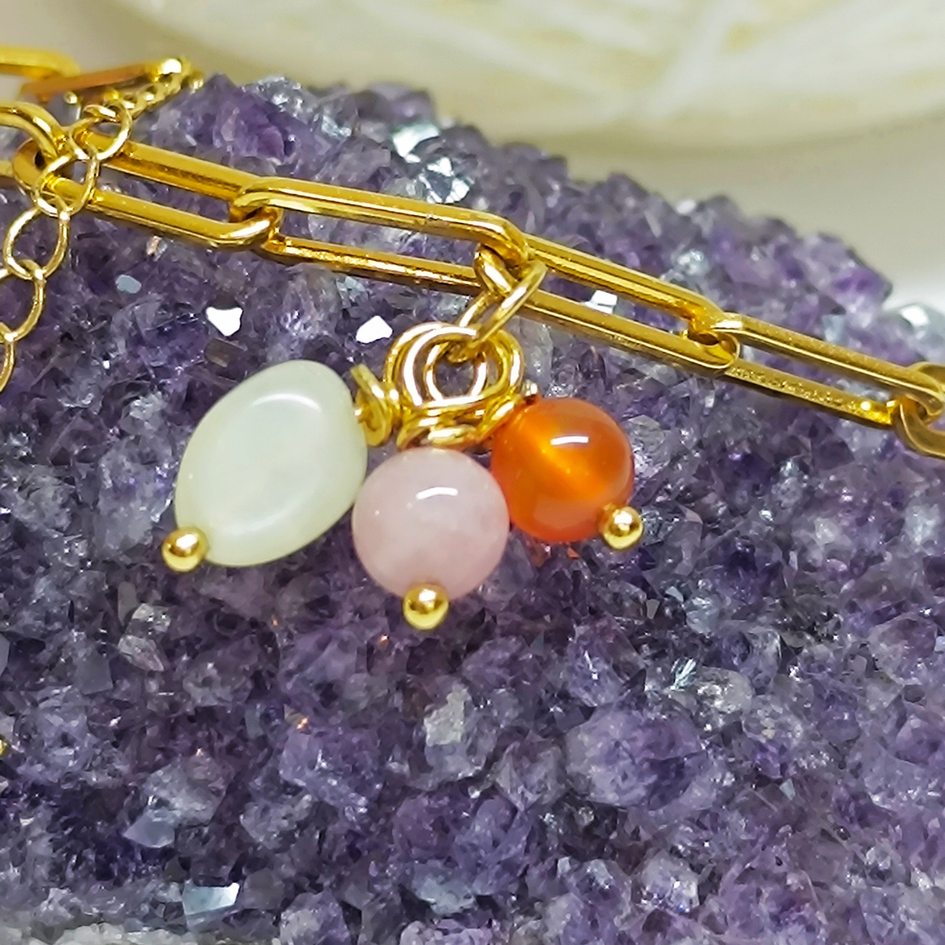 Gros plan sur les perles de cornaline orange, quartz rose et pierre de lune blanches du Bracelet ELISE, et le pendentif étoile du nord.