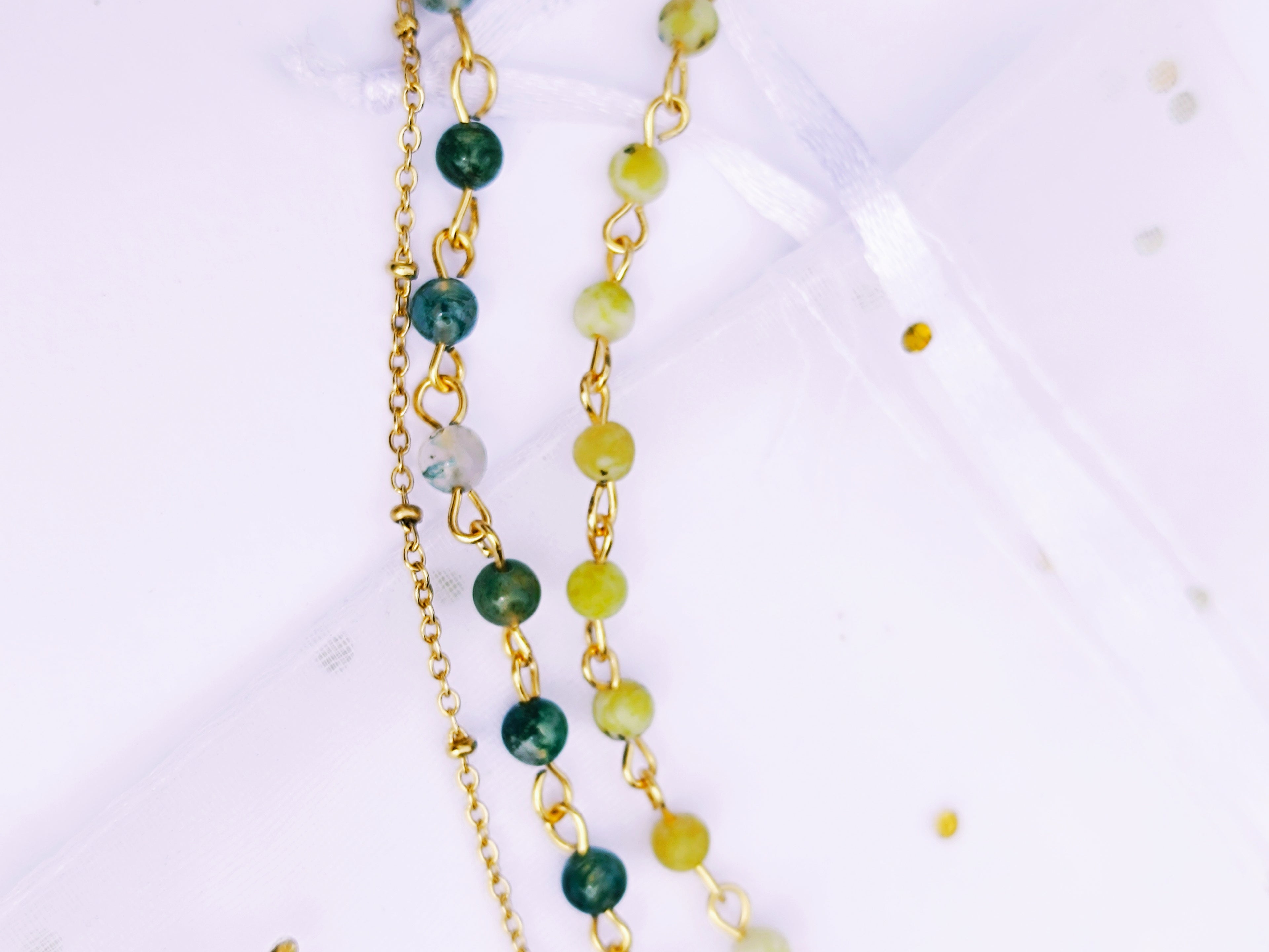 Détail rapproché du pendentif libellule doré et des perles d'Agate Mousse du bracelet double SANACA, montrant la finesse du bijou.