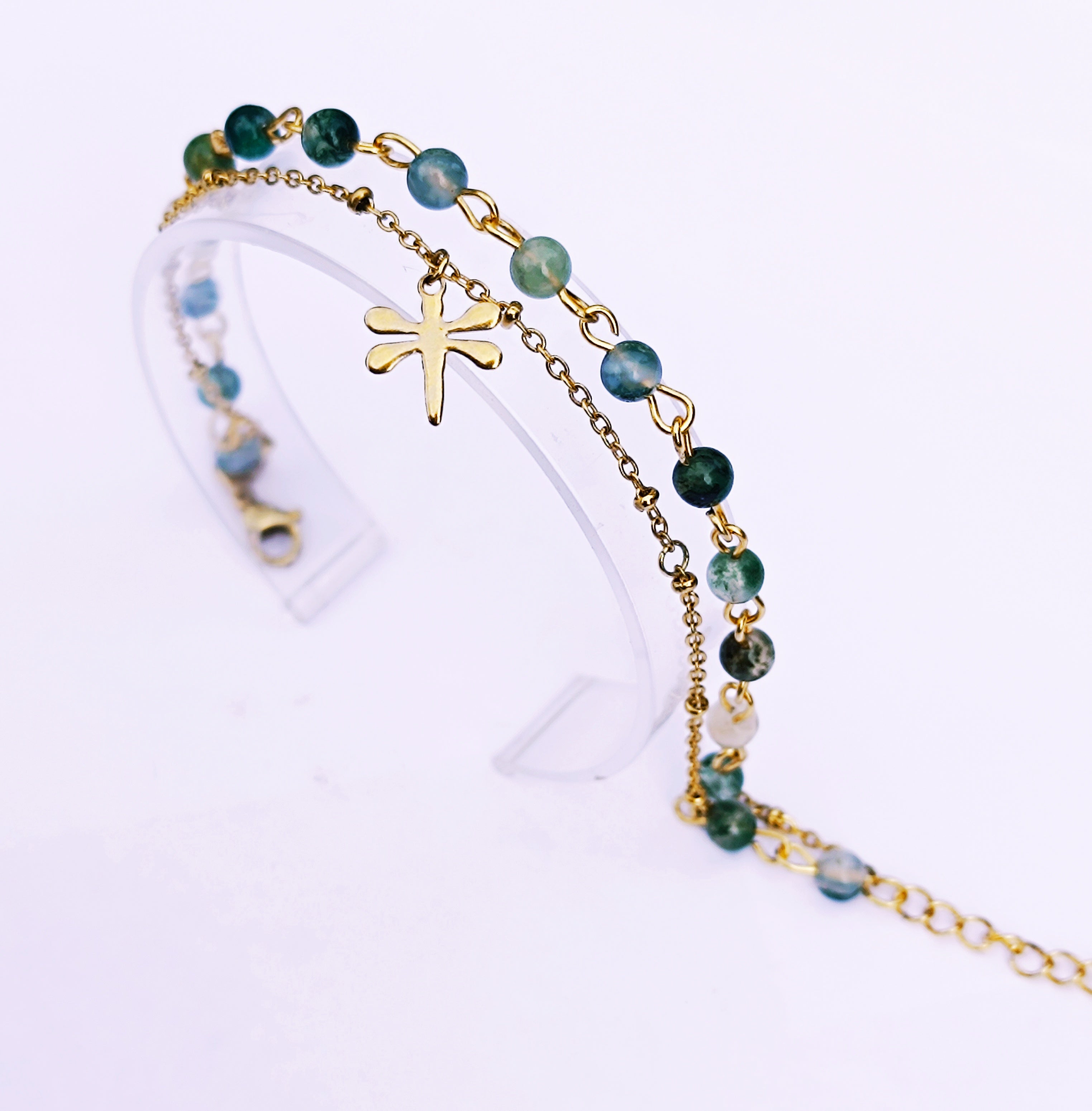 Bracelet double SANACA en Agate Mousse et acier inoxydable doré avec pendentif libellule, présenté sur un support transparent.