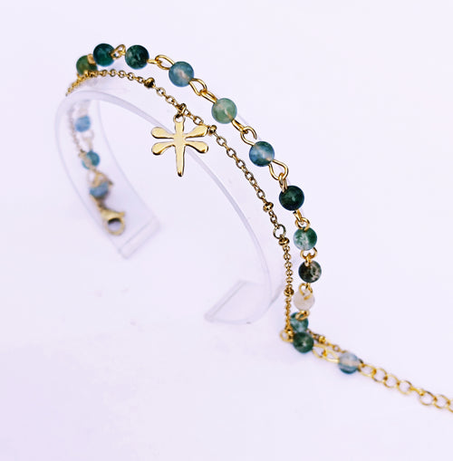 Bracelet double SANACA en Agate Mousse et acier inoxydable doré avec pendentif libellule, présenté sur un support transparent.