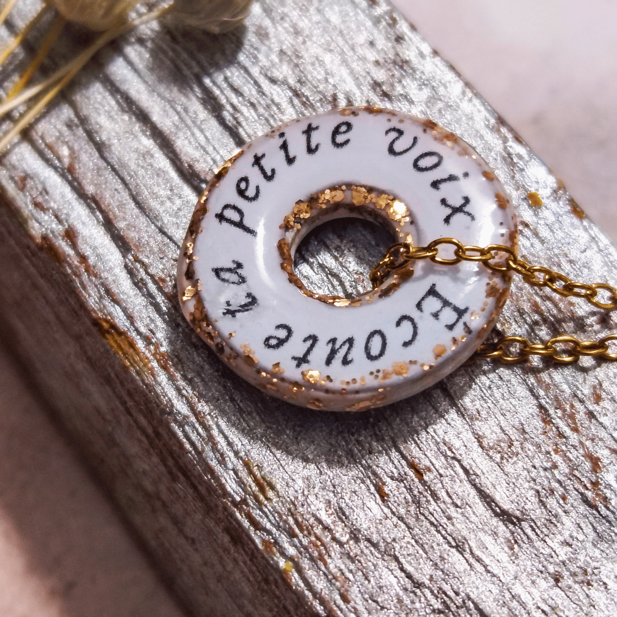 Vue de dos du pendentif "Le Murmure" scellé sous résine, révélant l'impression délicate du mantra "Écoute ta petite voix". Bijou de sagesse intérieure fait main, pièce unique.