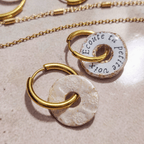 Vue de dos du pendentif "Le Murmure" scellé sous résine, révélant l'impression délicate du mantra "Écoute ta petite voix". Bijou de sagesse intérieure fait main, pièce unique.