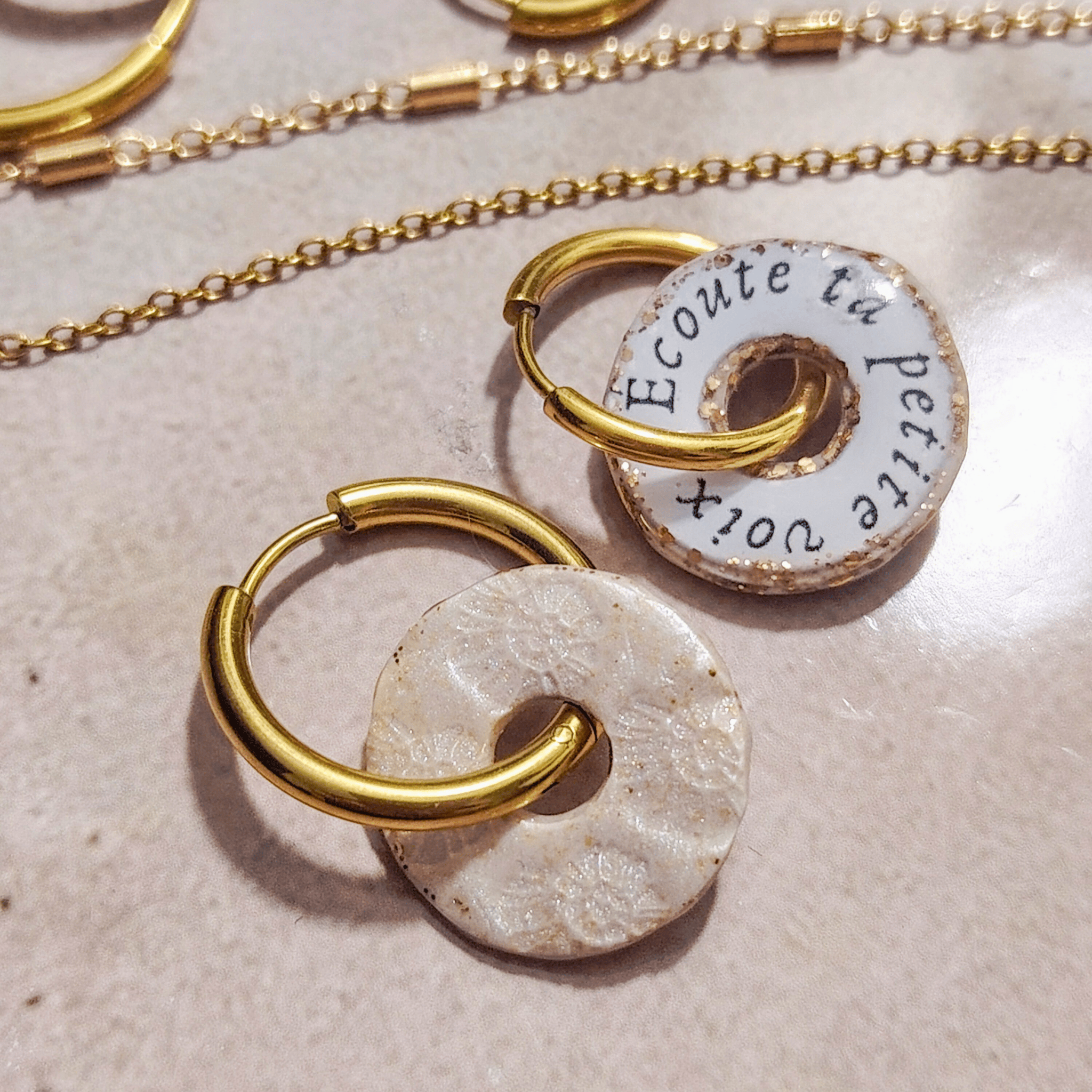 Vue de dos du pendentif "Le Murmure" scellé sous résine, révélant l'impression délicate du mantra "Écoute ta petite voix". Bijou de sagesse intérieure fait main, pièce unique.