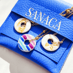 Présentation du bijou artisanal L'Équilibre dans son pochon bleu Sanaca, idéal pour un cadeau symbolique.