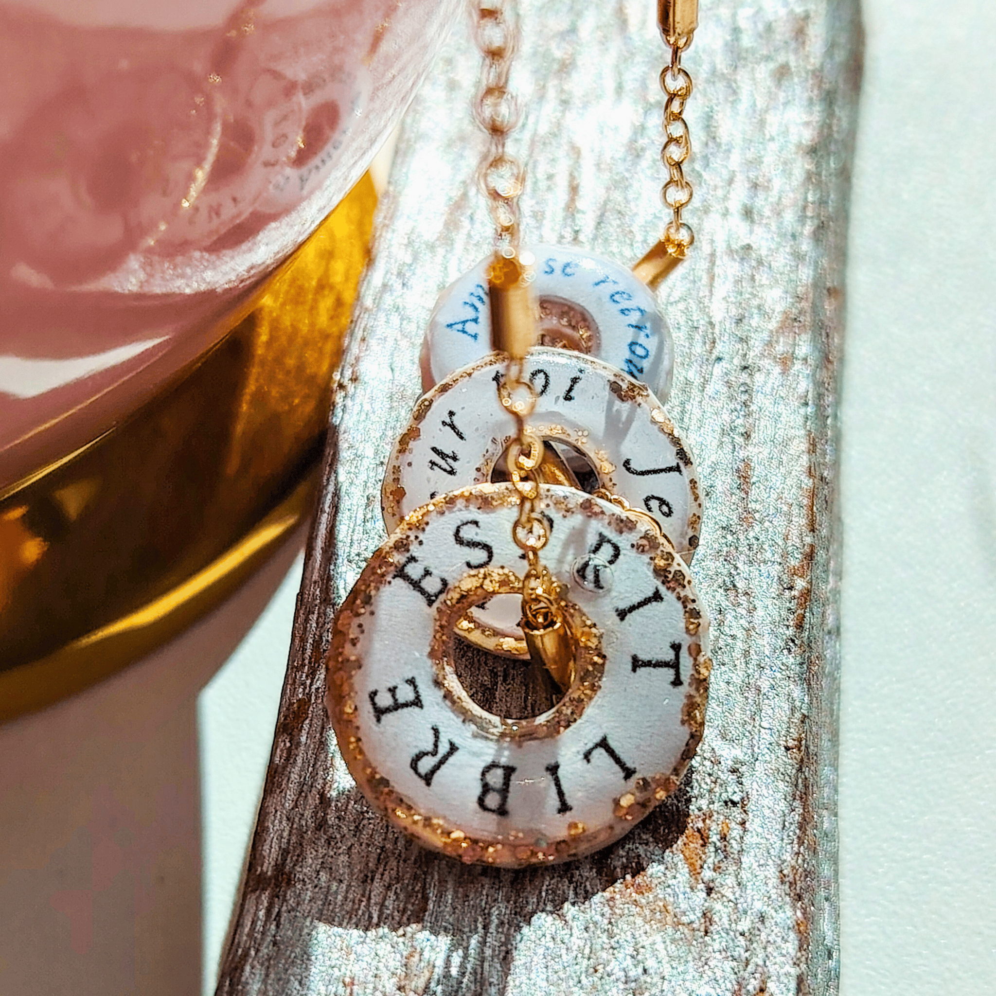 Alignement de pendentifs totems artisanaux mettant en avant le le texte mantra 