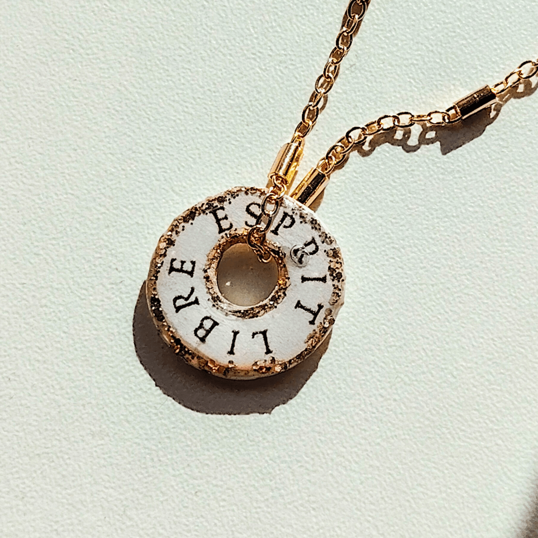 Médaille totem L'Équilibre avec mantra Esprit Libre gravé et finitions dorées artisanales.