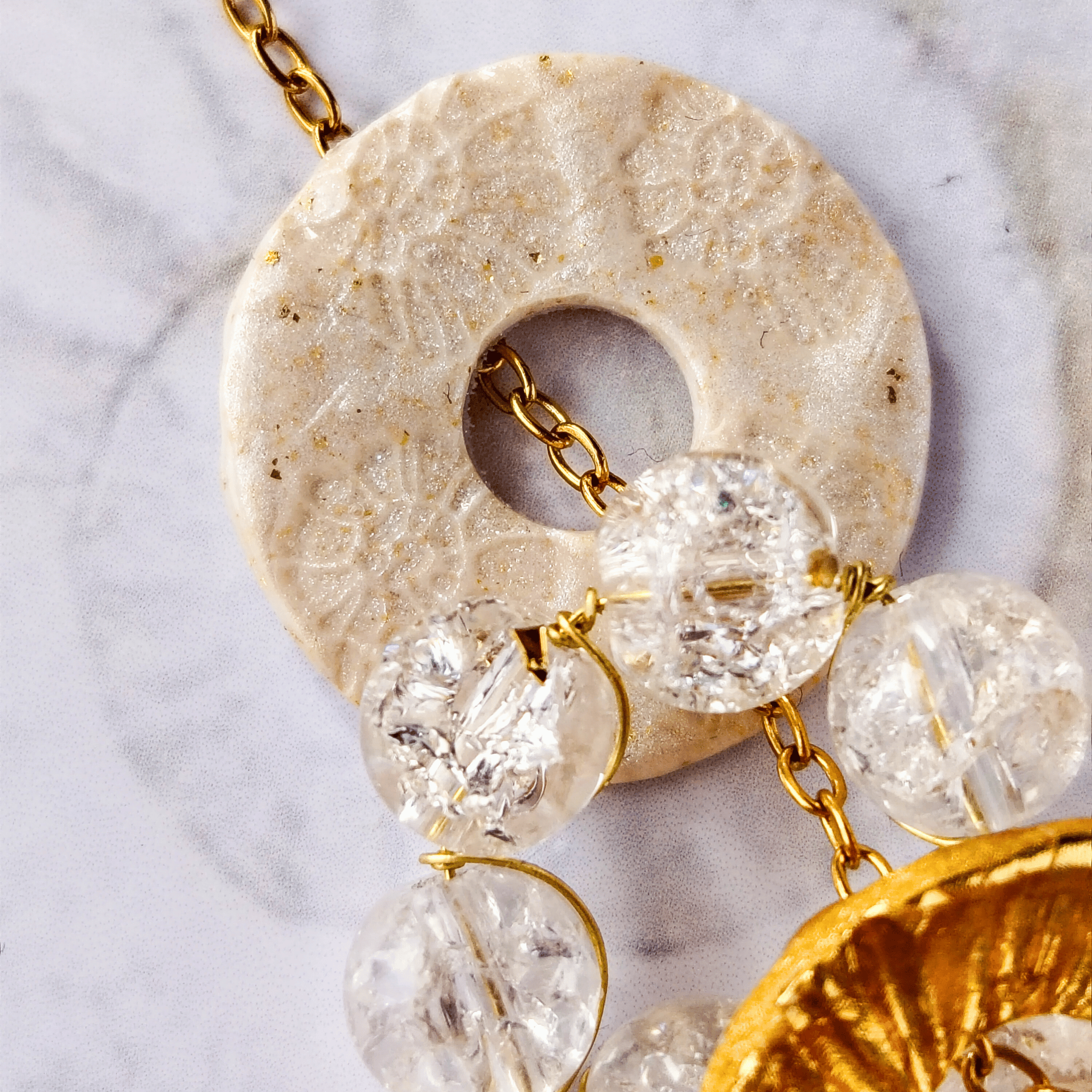 Zoom sur le Totem Spirale Le Murmure, une pièce unique avec perles de quartz transparent et pampille artisanale aux reflets dorés, Sanaca.