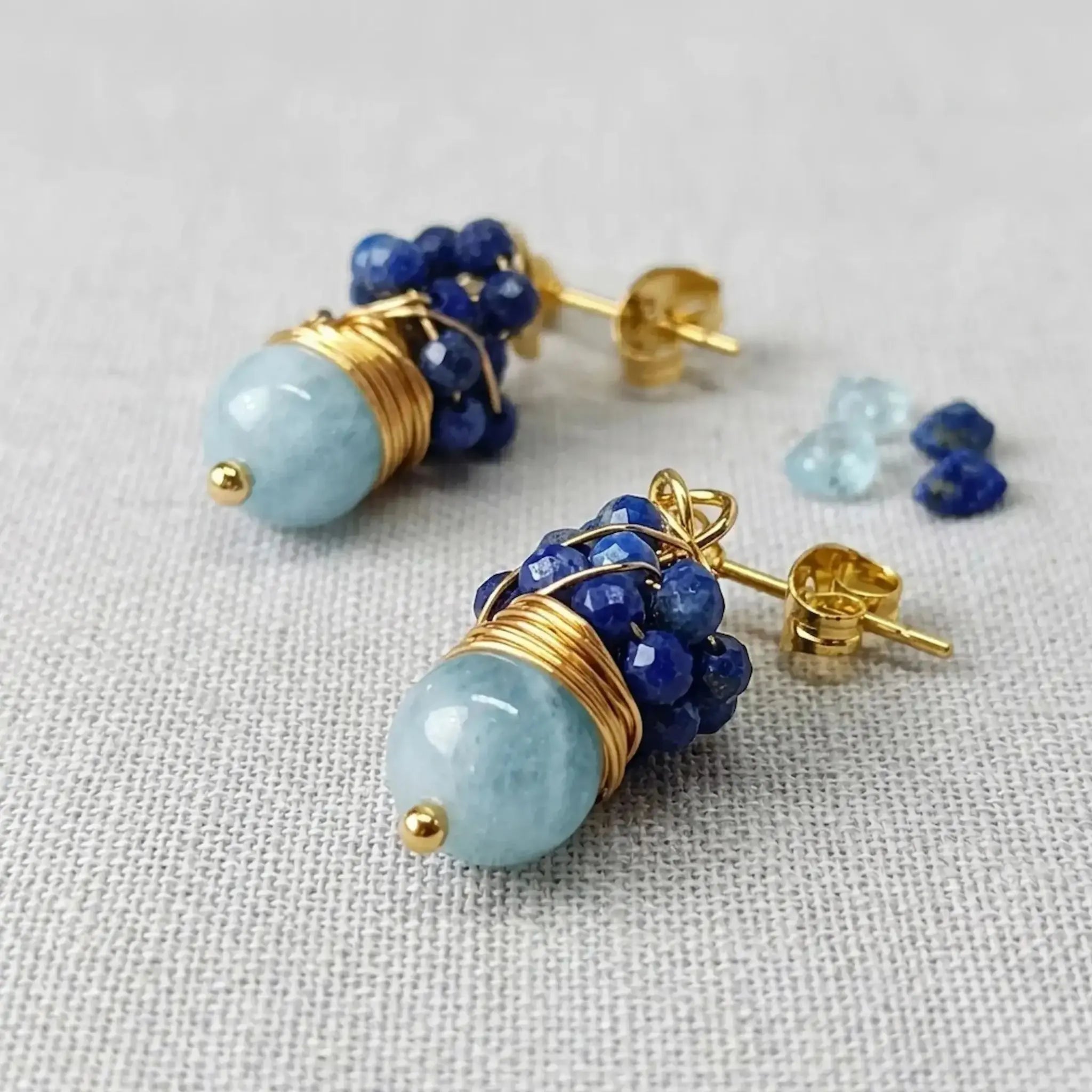 Détail des boucles d'oreilles Hossegor montrant la grappe de lapis-lazuli facetté et la perle d'aigue-marine