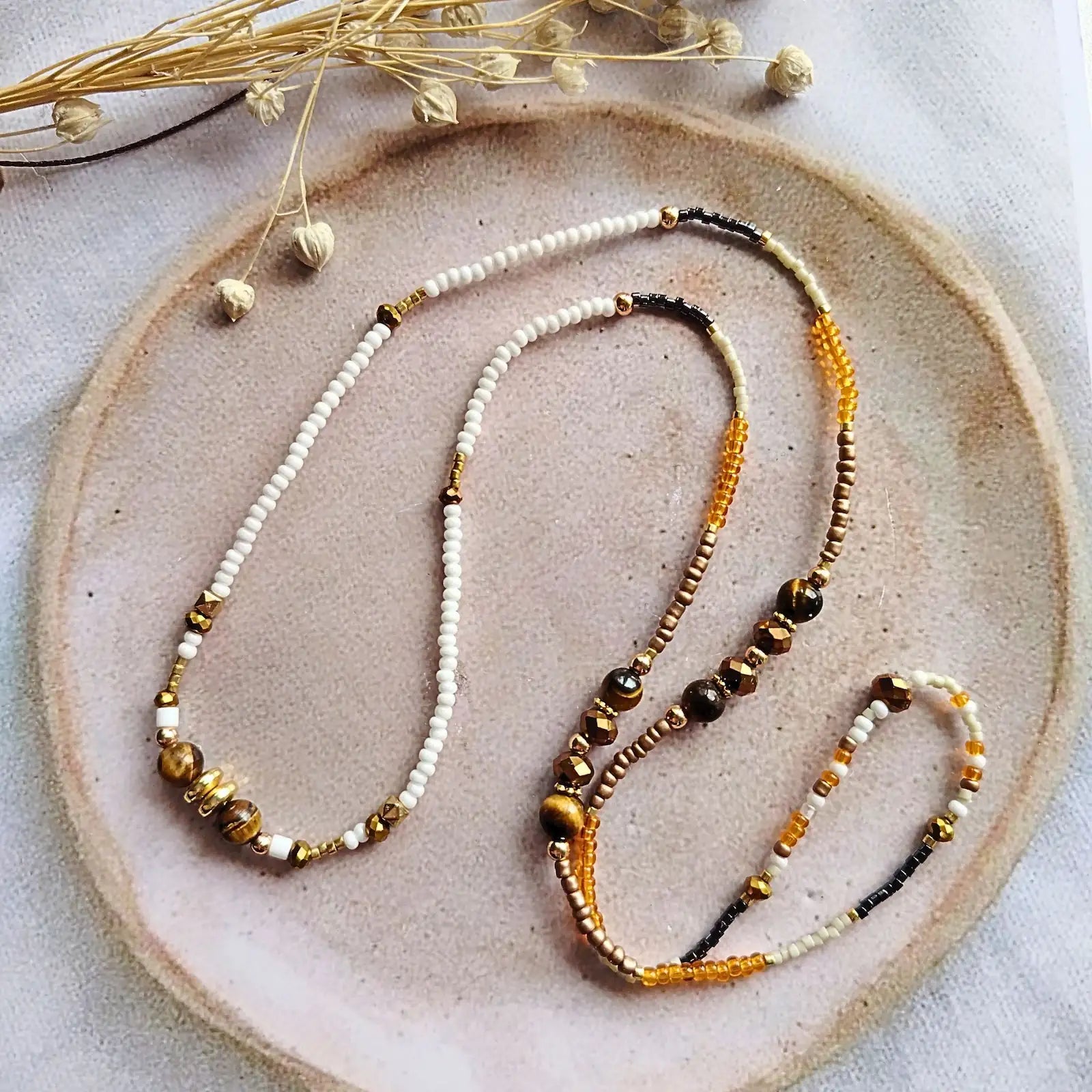 Bijou modulable Ambre présenté à plat sur une coupelle en céramique, design artisanal fait main dans le sud-ouest de la France.