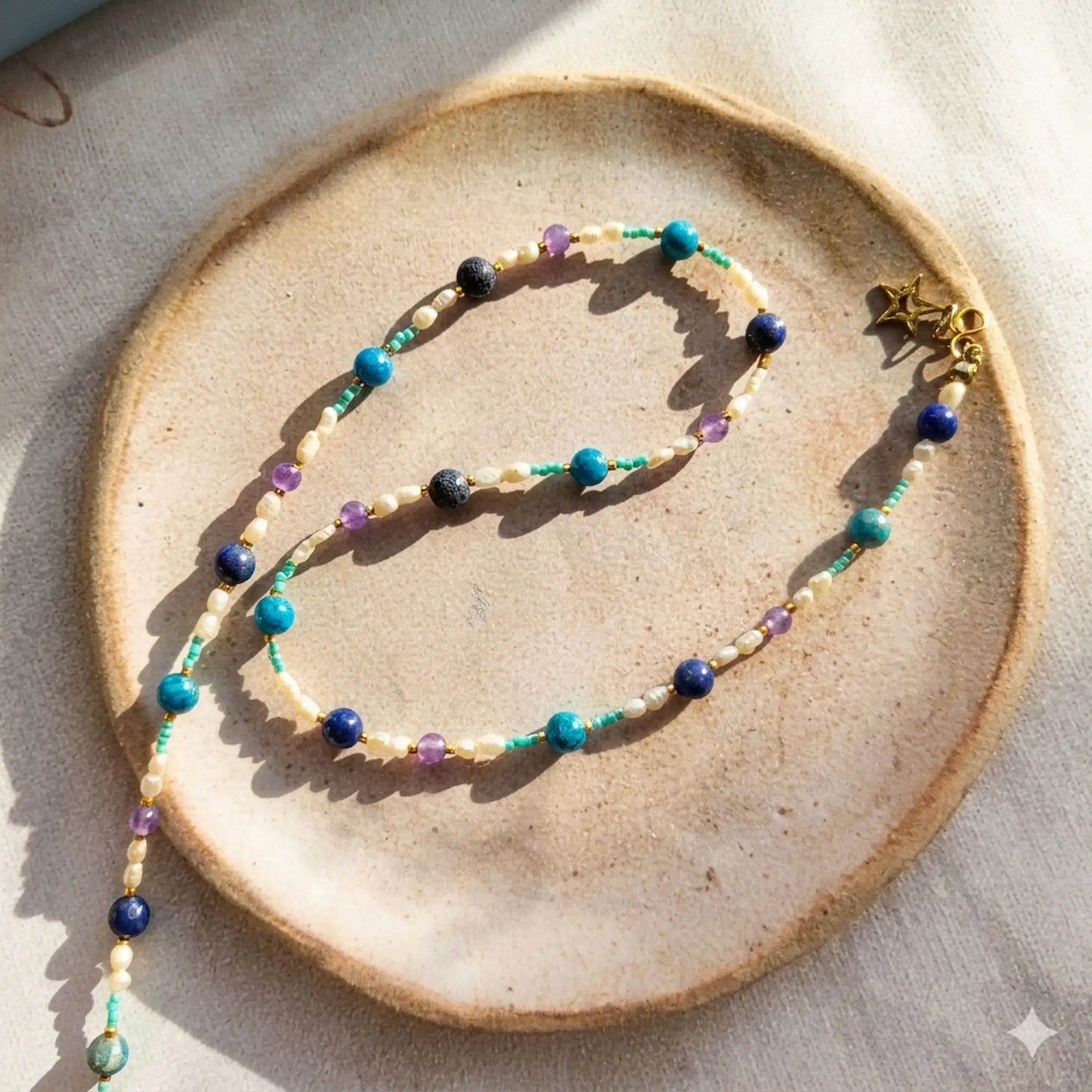 Bijou artisanal Collier Biarritz présenté sur une coupelle en céramique, perles de pierres fines et perles d'eau douce, création faite main.